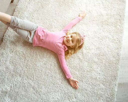 Cute girl lying on carpet flooring | Select Floors